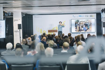 Ken De Cooman (BC Architects and Studies, Brüssel) präsentiert seine Arbeiten im Rahmen der Eröffnung vom Zukunft Bau Pop-up Campus Ken De Cooman auf der Bühne vor einem Publikum